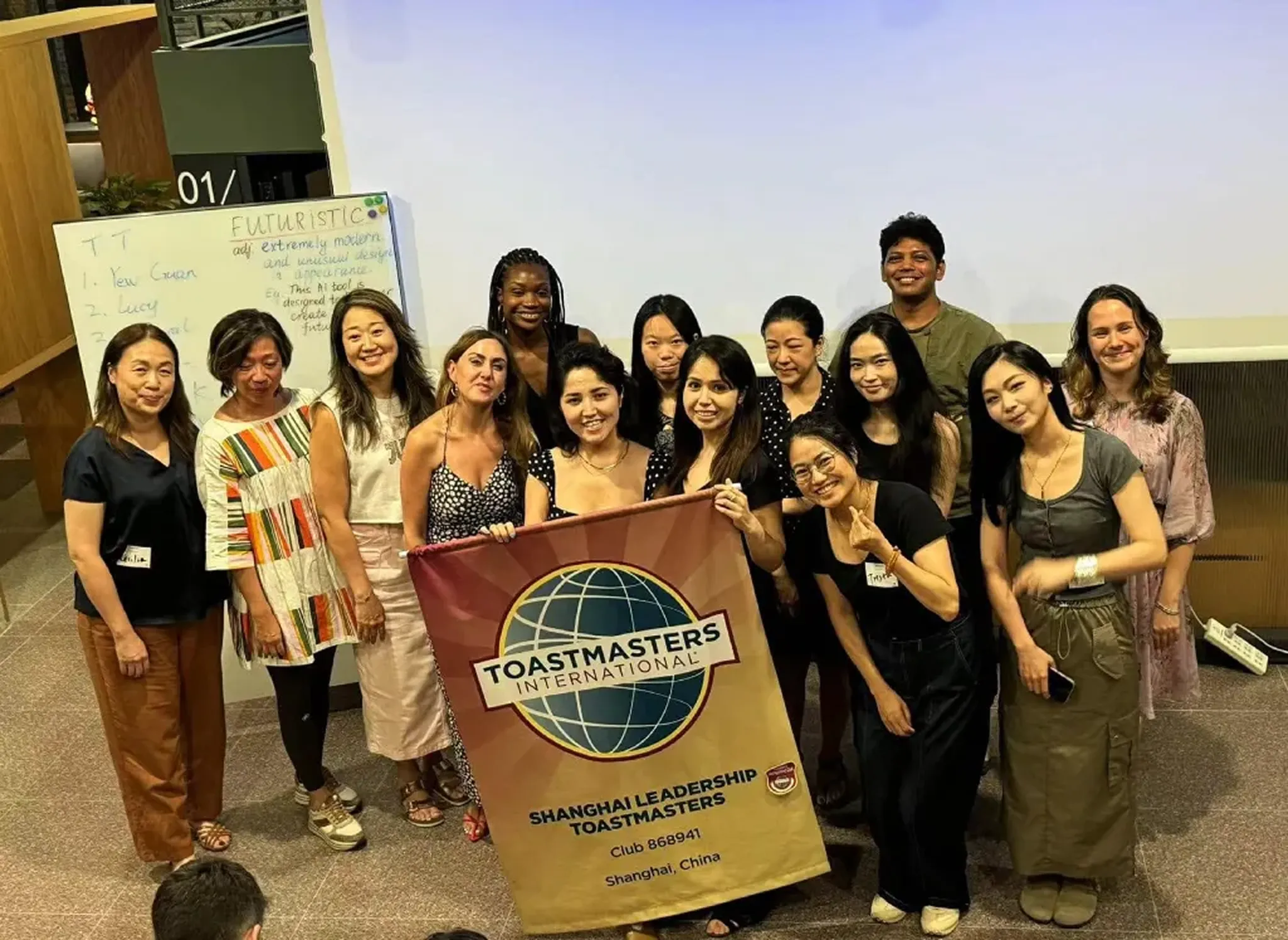 Shah Jaman with the Shanghai Leadership Toastmasters club, holding their banner.